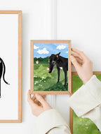 Woman is hanging a greyhound illustration print on a gallery wall of dog art