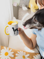Woman holds a ceramic mug next to a greyhound, the perfect dog gift idea