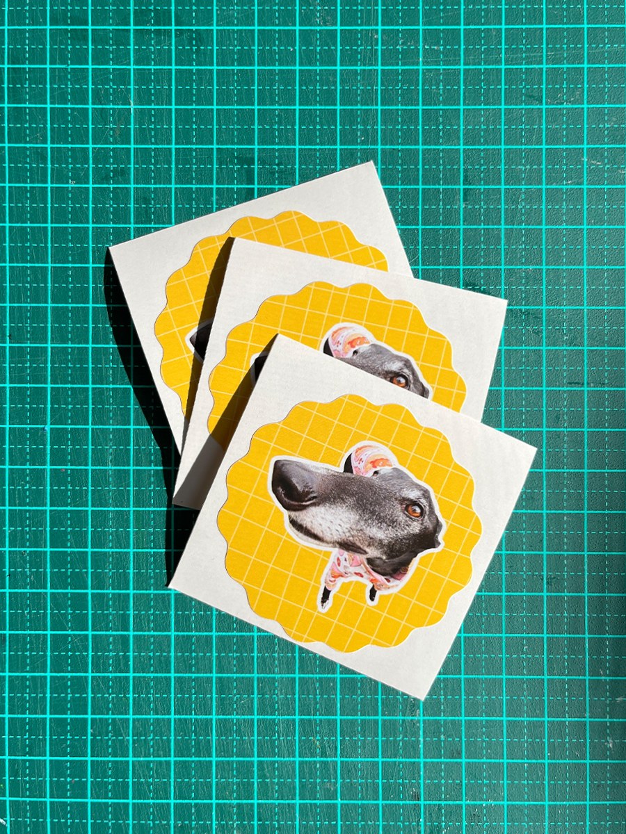 Three stickers with a dog design on a green grid background