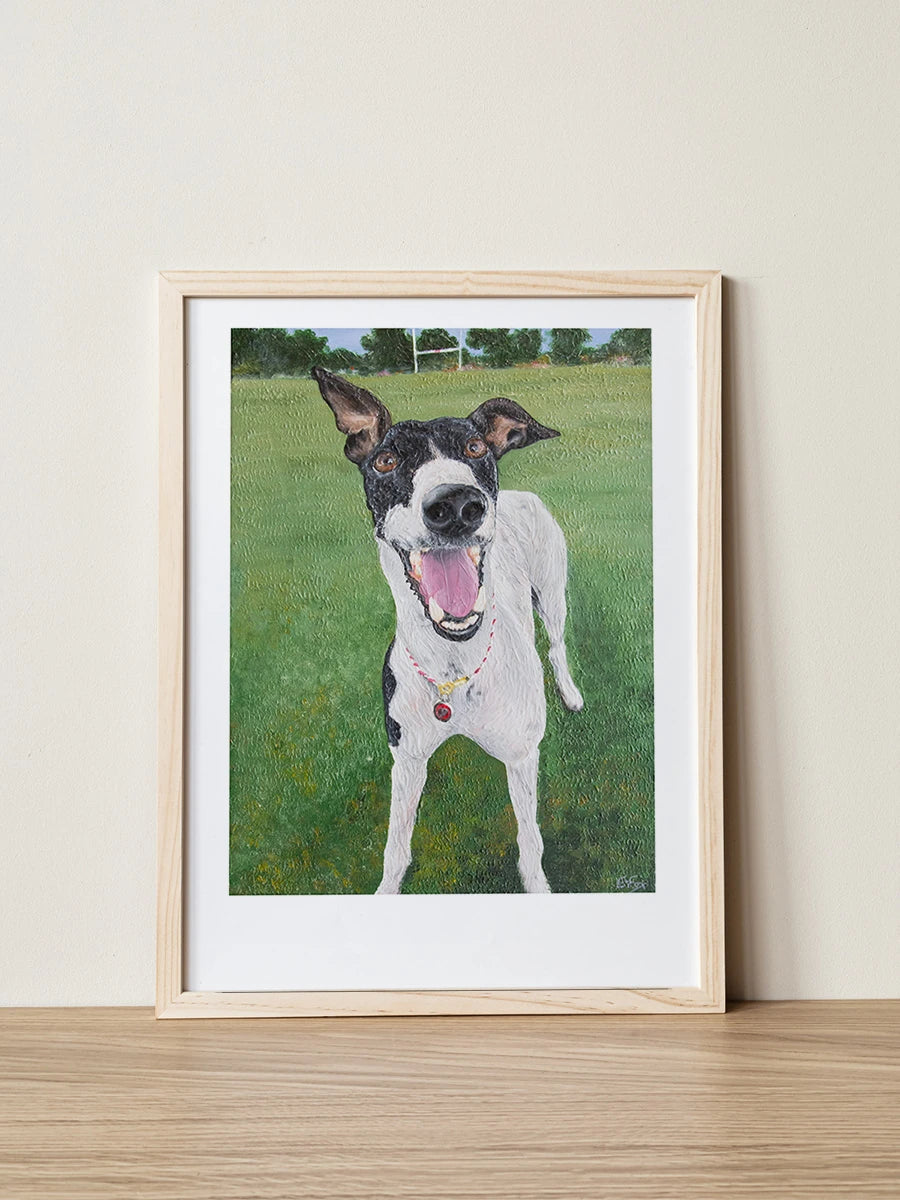 Portrait of Georgia the Greyhound, as painted by Elliott Fox for the Saint Grey art exhibition about greyhound advocacy. Georgia is smiling in a wooden frame with a grassy field behind her.