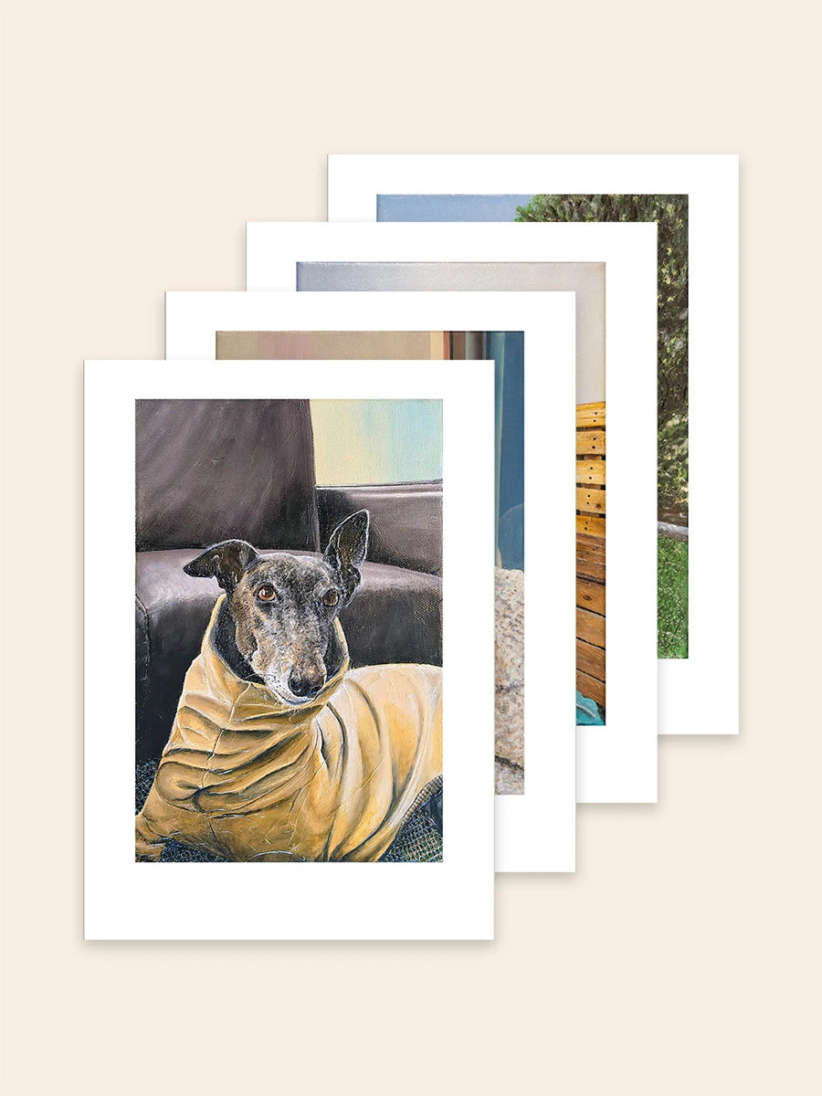 A set of four art prints by Elliott Fox fanned out on a light beige background. Each of the prints features a portrait of a greyhound from Diva, Bohemond, Orville, Winston and Bernard's family.