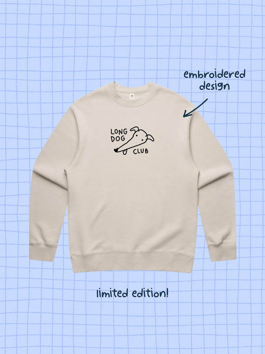 Beige sweatshirt with embroidered greyhound design on a blue grid background